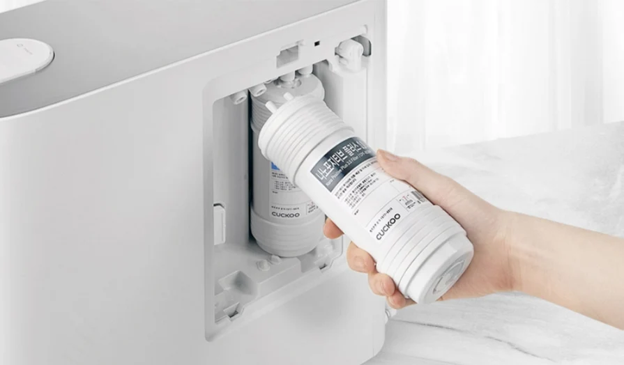 CUCKOO TN100 净水器,一只手正在更换或装入内部滤芯。(CP-TN100)